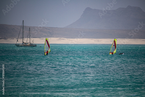 Windsurfers and a sailing boat  in the Sal Rei bay with the mountain Rocha Estância in background (Boa Vista Island, Cabo Verde, Africa)