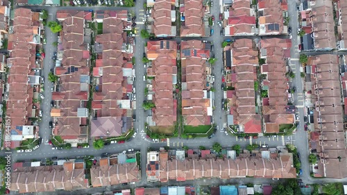 Abstract top-down aerial view of high-density housing with red tile roofs forming a neat grid pattern. Urban geometry.