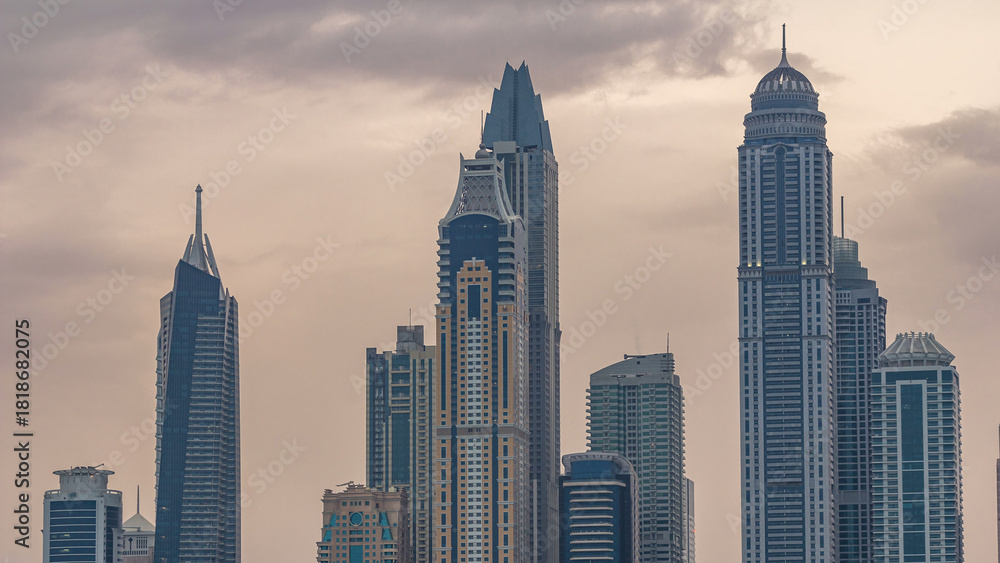 Obraz premium Modern skyscrapers in Dubai city night to day timelapse from the Palm Jumeirah Island.