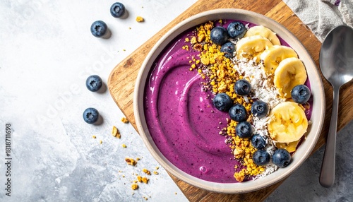 Acai breakfast superfoods smoothies bowl topped with bee pollen granola coconut flakes and blueberries. Overhead top view flat lay