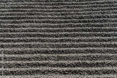 Raked Gravel Path With Uniform Lines Creating Textured Outdoor Garden Landscape