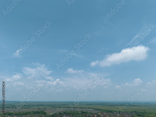Diverse aerial landscape shots from East Java, Indonesia, featuring dense forest canopy, agricultural fields, forested hillsides, and vast blue skies with dramatic clouds.
