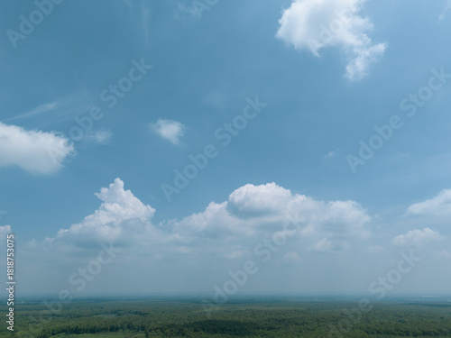 Diverse aerial landscape shots from East Java, Indonesia, featuring dense forest canopy, agricultural fields, forested hillsides, and vast blue skies with dramatic clouds.