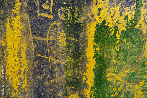 Weathered abstract wall with peeling yellow and green paint