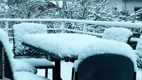 Snow covered outdoor terrace furniture near Grenoble after early winter snowfall, France