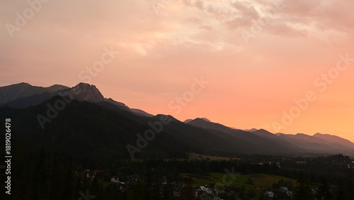 Fototapeta Naklejka Na Ścianę i Meble -  Beautiful, scenic sunset over Tatra mountains and Zakopane, Poland. Orange sky over the mountains