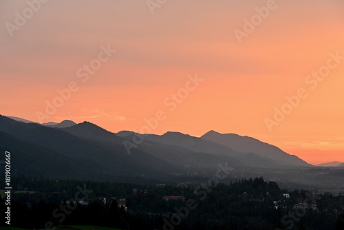Fototapeta Naklejka Na Ścianę i Meble -  Beautiful, scenic sunset over Tatra mountains and Zakopane, Poland. Orange sky over the mountains