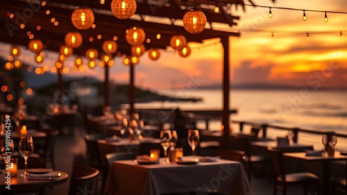 Golden orbs of light illuminate a coastal dining area during a picturesque sunset.