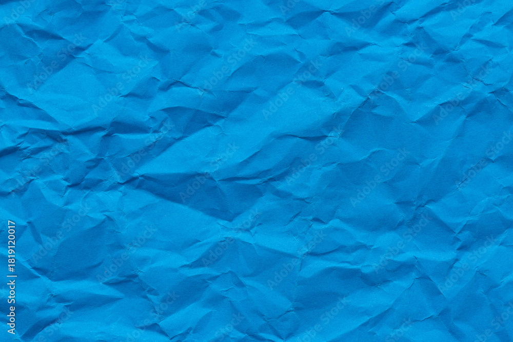 Obraz premium Close-up macro crumpled blue paper background,Abstract blue paper texture as background. Texture of slightly crumpled craft paper. Paper background. Recycled blue paper backdrop in close up.