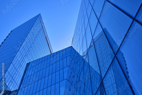 Futuristic blue glass high-rise skyscrapers facade. Low-angle view of modern corporate office buildings in a financial district. Business, finance, and contemporary architecture concept photo