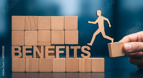 Wooden blocks spell out benefits with a cutout figure stepping up symbolizing employee perks and advantages creating a visual representation of growth and opportunity in business