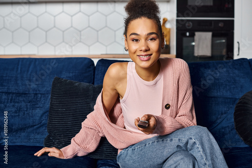 Fotografie Cozy moments at home with a young adult enjoying time on the sofa watching telev