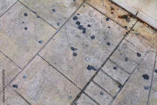 City cleanness. Black chewing gum spots on urban sidewalk in Alicante, Spain. Old chewing gums of city pavement surface.