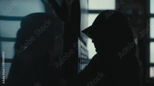 Silhouette of Female Worker Facing Tool Cabinet in Backlight