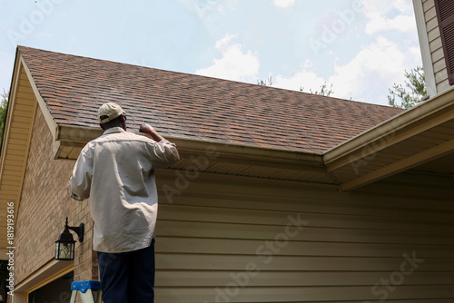 фотографія A portrait of a black man cleaning out gutters
