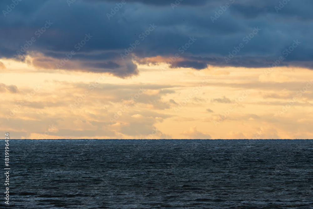 Ταπετσαρία Dramatic golden sunset sky with dark heavy clouds over the choppy Baltic Sea hor