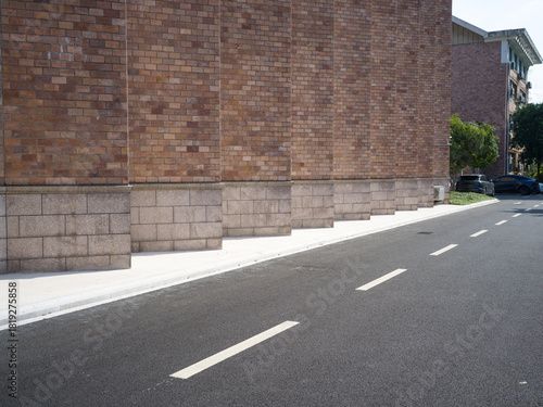 Fototapeta Naklejka Na Ścianę i Meble -  Brick building, paved road, small vents and street lamp
