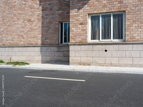 Fototapeta Naklejka Na Ścianę i Meble -  Brick building, paved road, small vents and street lamp
