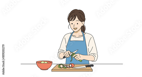 Young woman in an apron peeling a green vegetable while preparing food in a kitchen.