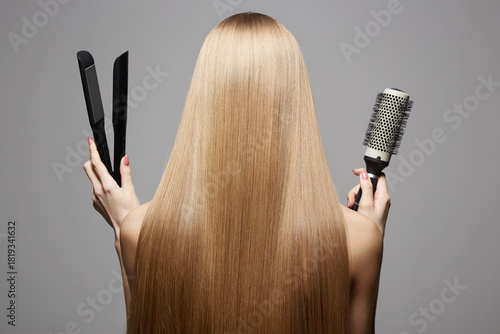 beautiful blond hair woman holding styling accessories. Back of girl with Healthy hair