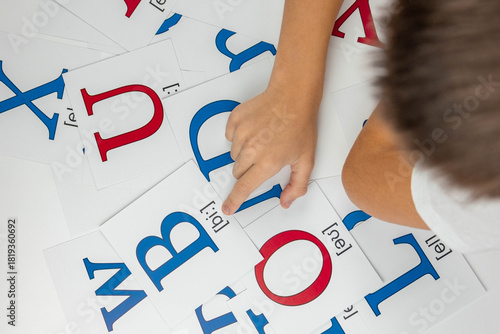 Canvas Print Phonics learning: child pointing at the letter B and its transcription on a flas