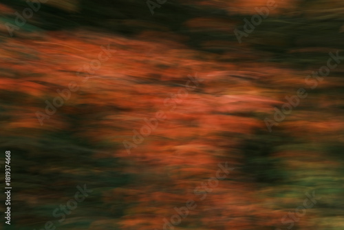 A blurry image of leaves and branches with a greenish tint