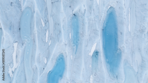 Aerial view of a glacier's icy terrain, where turquoise pools nestle amidst the stark white expanse, creating a mesmerizing contrast, Jokulsarlon, Sveitarfelagid Hornafjordur, Iceland.