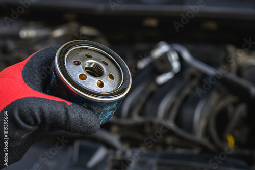 Auto mechanic holding an old oil filter that has been used