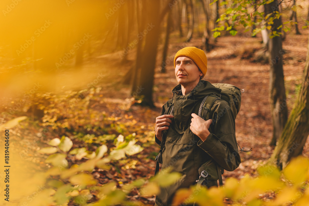 Fototapeta premium Man Backpacker in Yellow Beanie Walking in Woods