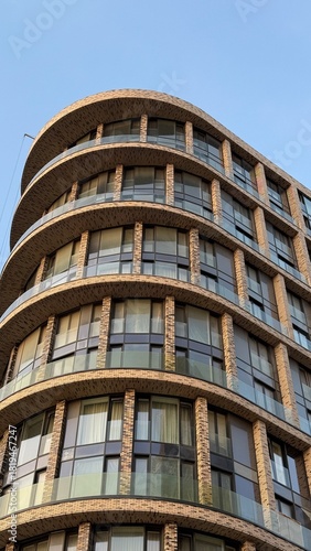 Modern rounded brick apartment building against clear sky