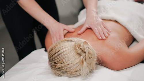 Professional hands performing massage giving blonde woman deep relaxation.