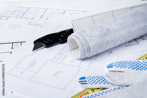 Laying flooring. Linoleum, a knife and a house plan on the builder's table. Taking measurements for laying the floor..