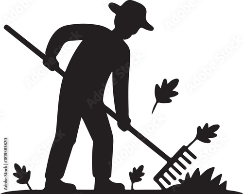 Silhouette of a farmer raking leaves in a field during autumn