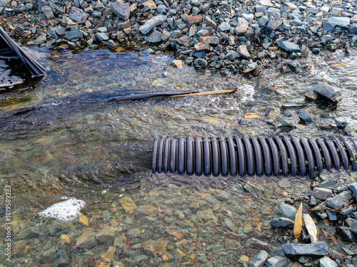 Flood damage on a small river caused by heavy rain and an undersized culvert.