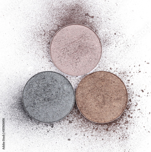 beige, blue and brown eyeshadows in refill pans isolated on white background
