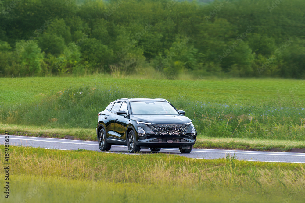 Fototapeta premium Modern Chinese made car on rural highway