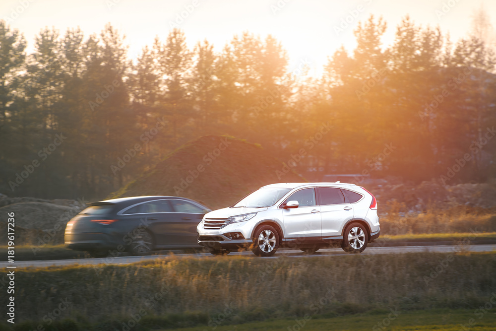 Fototapeta premium SUV driving on a sunny country road