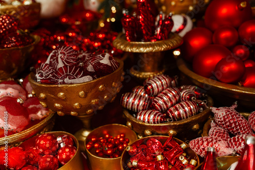 Luxurious Christmas ornaments in rich reds and golds, artfully arranged in vintage bowls. Festive, warm, and opulent — perfect for holiday marketing or seasonal decor inspiration.