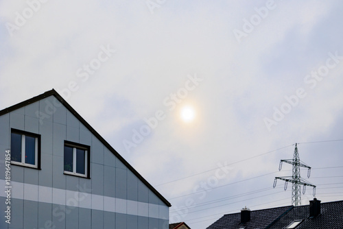 Soft winter sunlight over residential rooftops and power lines Germany, Munich, 21 November 2025