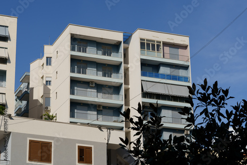 A light blue building with minimalistic design and clean horizontal lines. Perfect for digital nomads, city rentals, investment properties, and long-term living in Albania’s coastal towns.