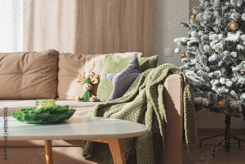 Cozy Living Room with Crocheted Reindeer Toy on Sofa and Christmas Holiday Candle Decor on Table