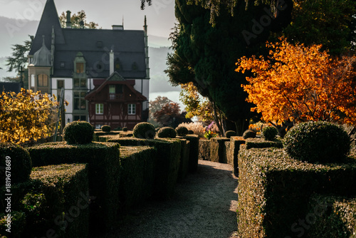 European castle in Switzerland with trimmed bushes and fall landscape