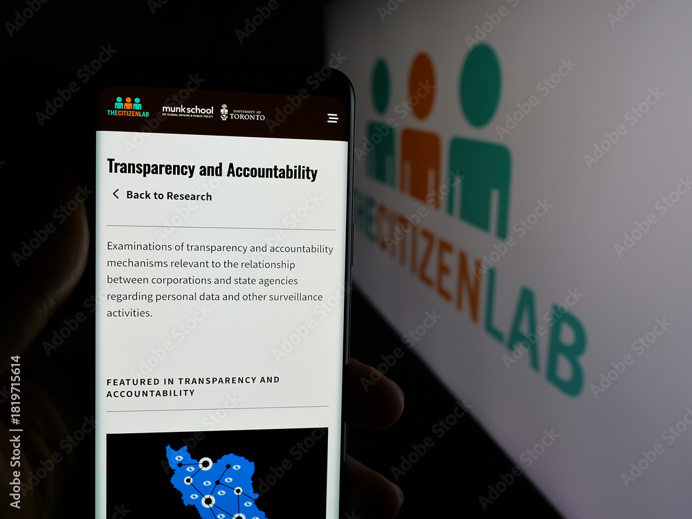 Fototapeta premium Stuttgart, Germany - 11-19-2025: Person holding smartphone with web page of Canadian research laboratory Citizen Lab on screen in front of logo. Focus on center of phone display.