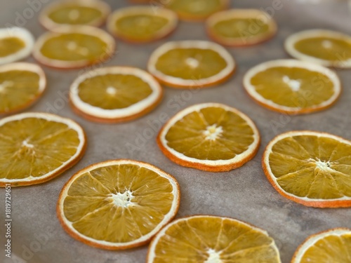 Close-up of dried orange slices arranged on parchment paper, perfect for crafts, decor, or homemade gifts.