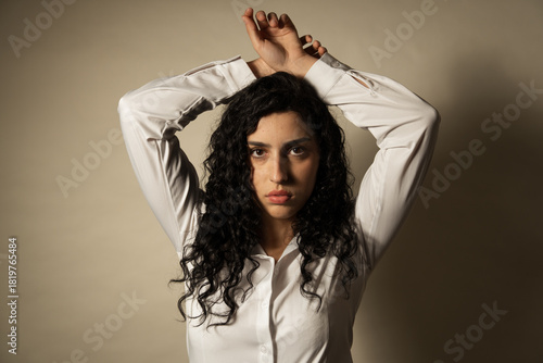 фотографія Woman posing with arms up showing vulnerability and defiance