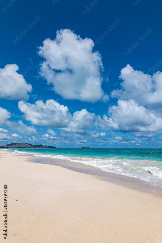 Fototapeta premium Waimānalo Beach Park, Honolulu, Windward Coast Oahu, Hawaii. Pacific Ocean. Cumulus clouds are clouds that have flat bases and are often described as puffy, cotton-like, or fluffy in appearance. 