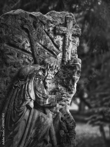 Photography Stone relief of Jesus praying before the cross at Goat Gate Cemetery in Bratislava, photographed in black and white