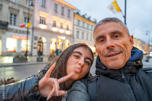 Father and daughter walking along a street in Warsaw enjoying sightseeing and urban atmosphere