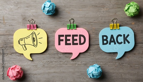 Three speech bubbles with the word FEED BACK and a megaphone, with colorful paper balls.