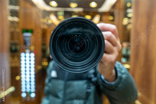 Urban photography of photographer using elevator mirrors to frame artistic reflections and symmetry